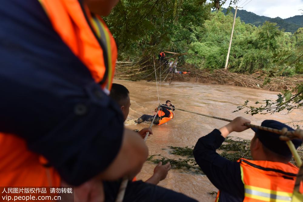 6月13日，消防救援大隊正在從河對面救援被洪水圍困的兒童。