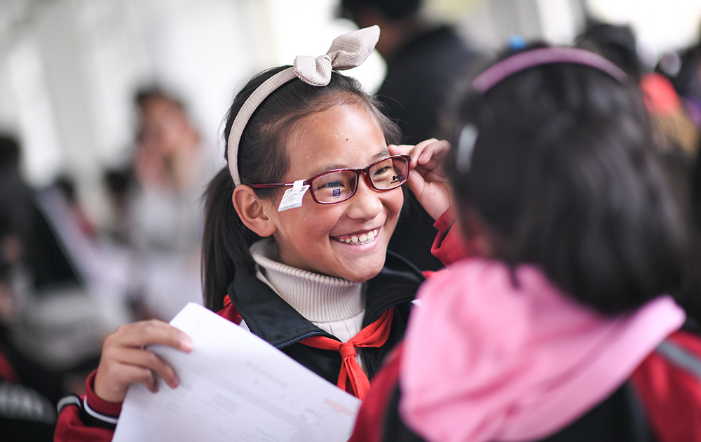 6月17日，在若尔盖县中学，戴上镜框的扎西旺姆开心不已。