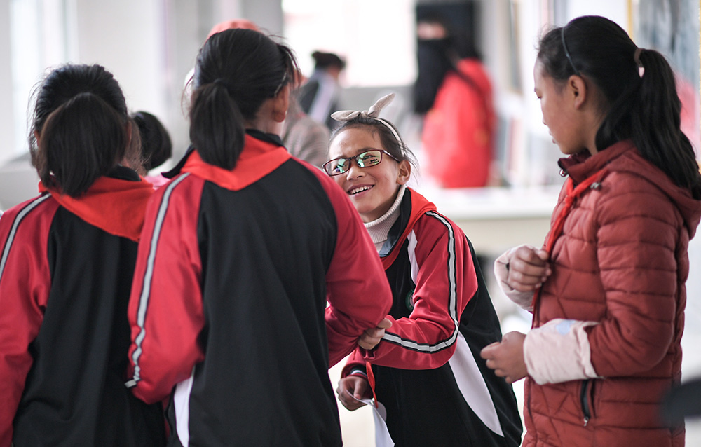 6月17日，在若尔盖县中学，扎西旺姆戴着挑选的镜框与同学们聊天。