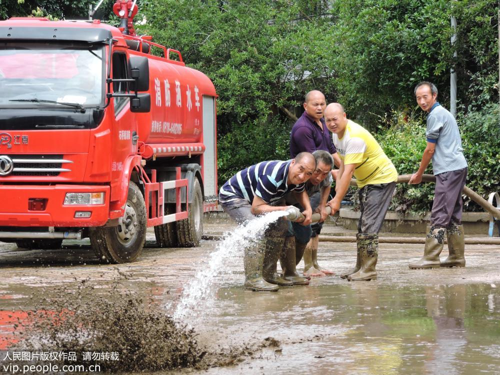 6月23日，四川省達州市大竹縣基層黨員干部在永勝鎮敬老院清理洪水退落后的淤泥。