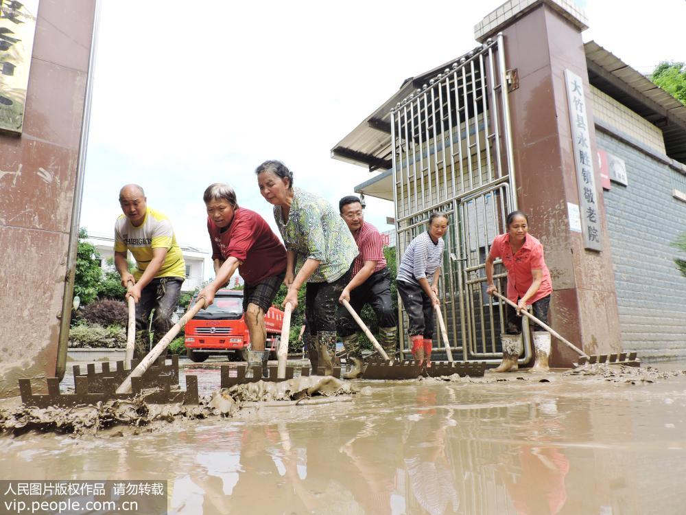 6月23日，四川省達州市大竹縣基層黨員干部在永勝鎮敬老院清理洪水退落后的淤泥。