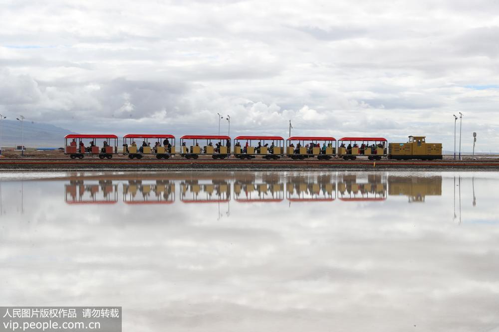 6月26日，一列旅游觀光車在位於青海省海西蒙古族藏族自治州烏蘭縣茶卡鎮的茶卡鹽湖景區內行駛。