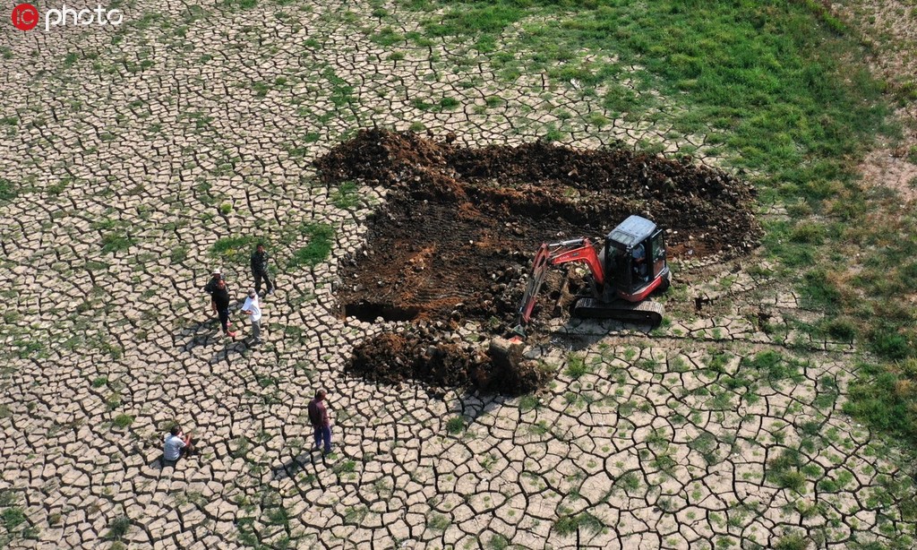 6月27日，在山東省蓬萊市南王街道魏庄村，農民在已經干涸的水庫底部“挖井”取水抗旱。（無人機拍攝）