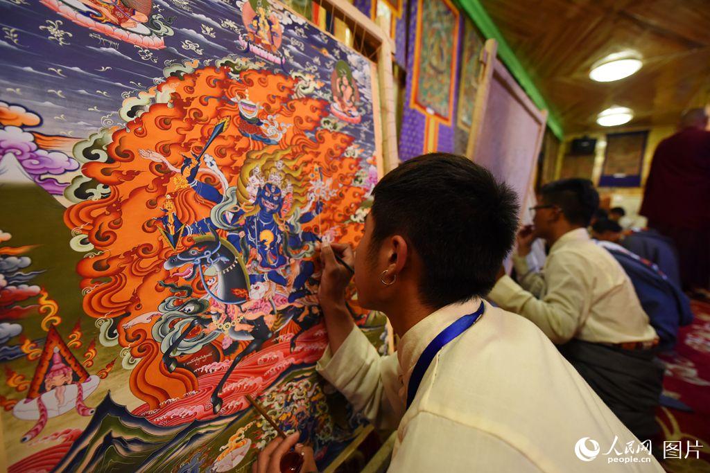 郎依寺為傳承象雄本波畫派民族工藝文化，建立了郎依甲唐卡藝術傳習基地，有很多年輕學生在此學習，圖為郎依大寺內正在作畫的學生。（人民網 馮粒 攝）