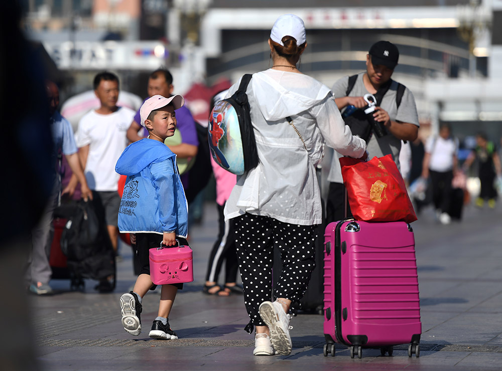 7月1日，北京站廣場上准備進站的旅客。（人民網記者 翁奇羽 攝）