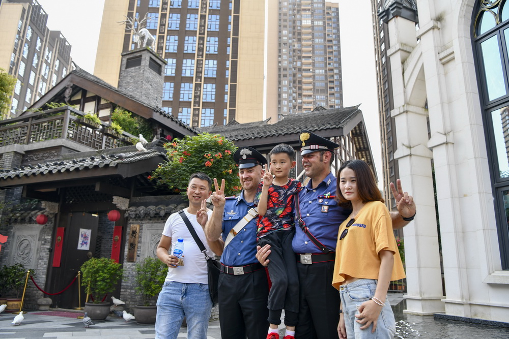 7月2日，中意聯合巡邏小組的兩名意大利警員在重慶市南岸區彈子石老街和游客合影。