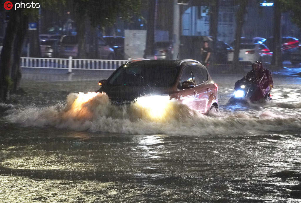 車輛冒雨從南寧市高新區積水嚴重的科德新苑路口經過。喻湘泉/東方ic