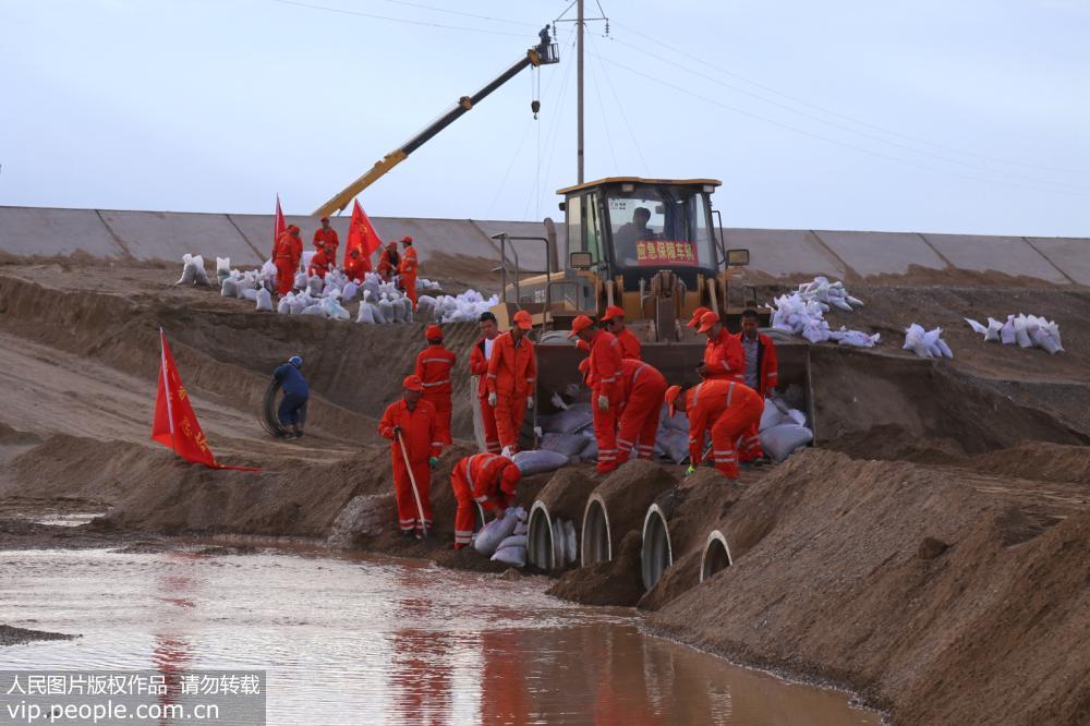 7月7日，甘肅省酒泉公路局應急搶險隊伍在水毀路段附近開設的便道安裝波紋管。