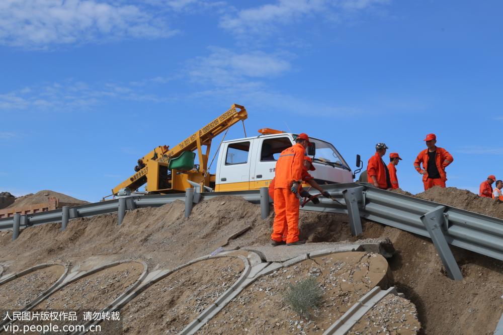 7月7日，甘肅省酒泉公路局職工在水毀路段整修波形梁護欄。