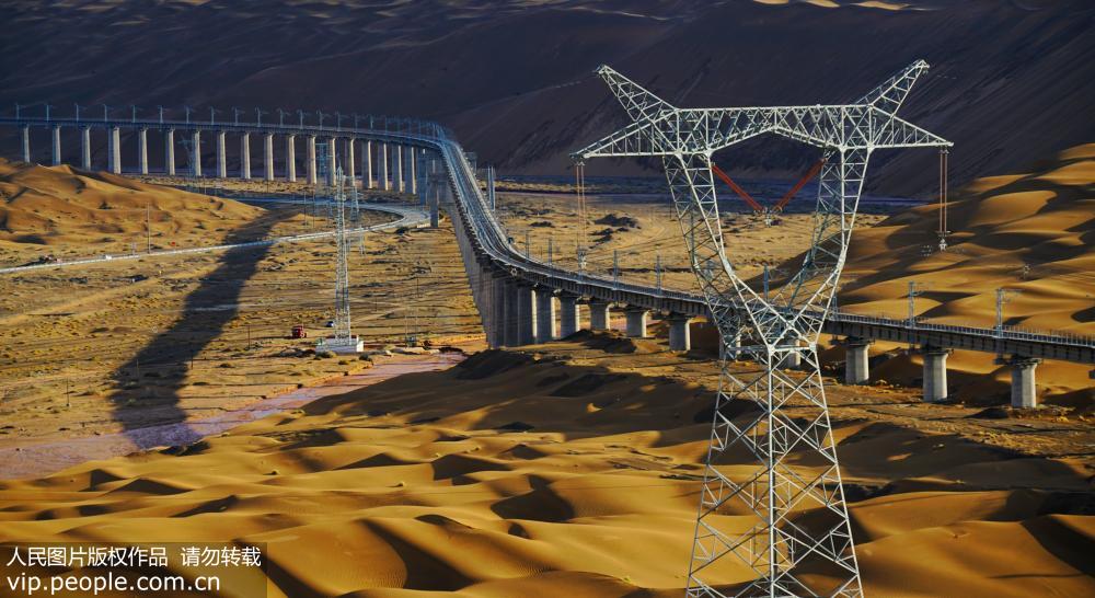 7月7日，雨后的敦格鐵路沙山溝特大橋在光影的渲染下猶如一條蛟龍穿行在沙漠中。