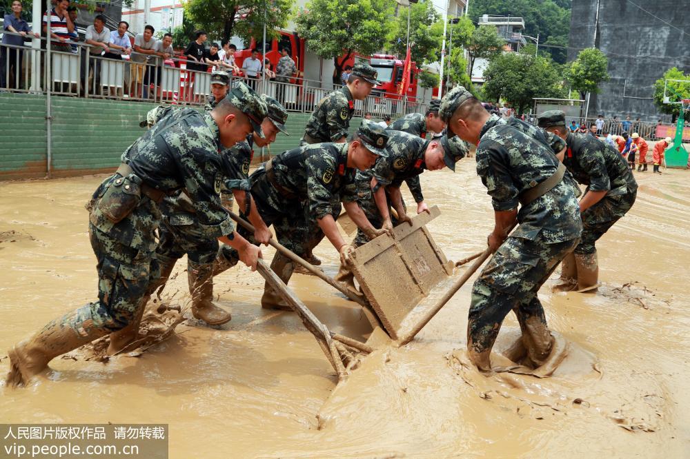 7月8日，武警官兵正在東蘭縣同樂村受災安置點清理淤泥。