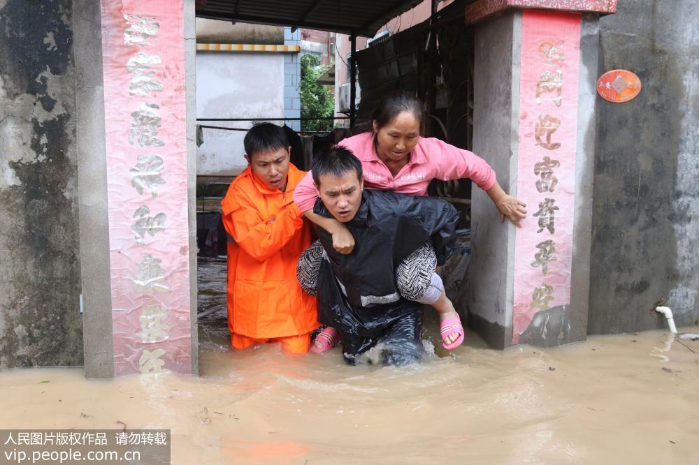 7月22日，在廈門市海滄區貞岱村，消防人員在轉移被洪水圍困的居民。