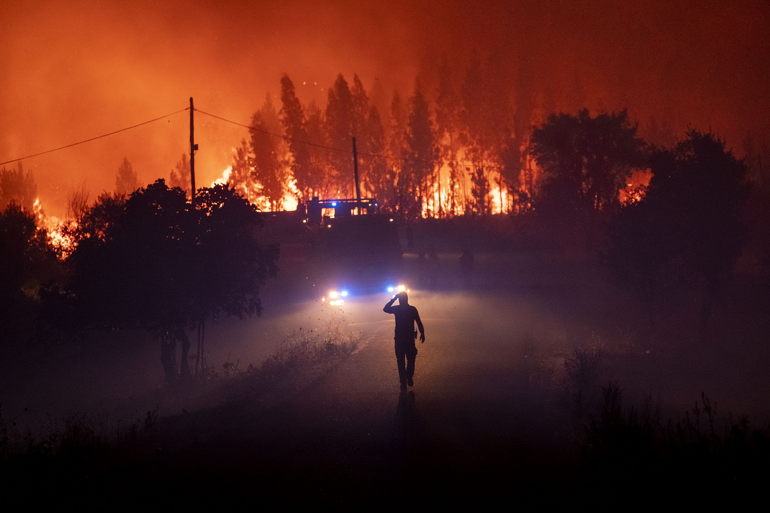 7月21日，在葡萄牙中部的卡爾迪古什村外，消防人員在火場作業。