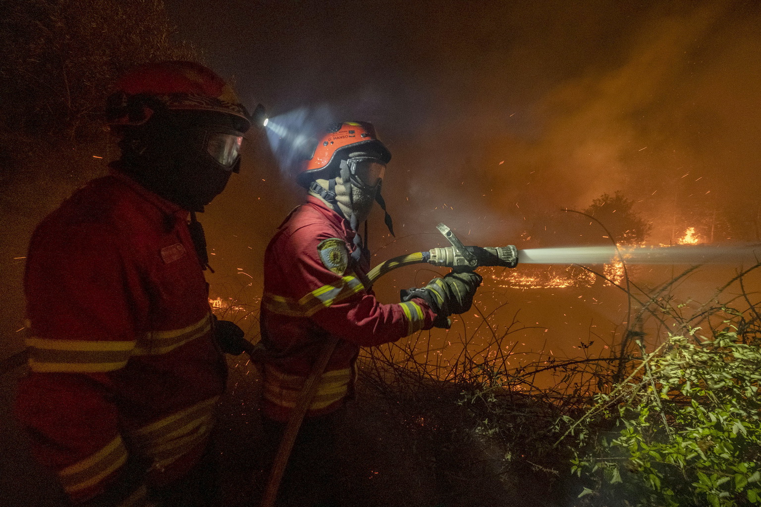 7月21日，在葡萄牙中部的卡爾迪古什村外，消防人員在火場作業。
