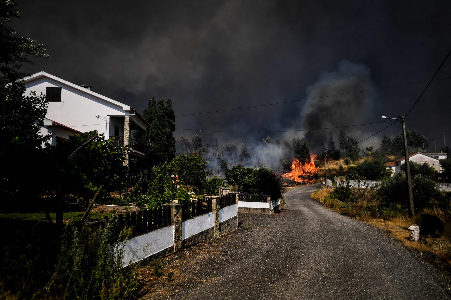 7月21日，在葡萄牙中部的卡薩斯-達裡貝拉村，火焰逼近房屋。