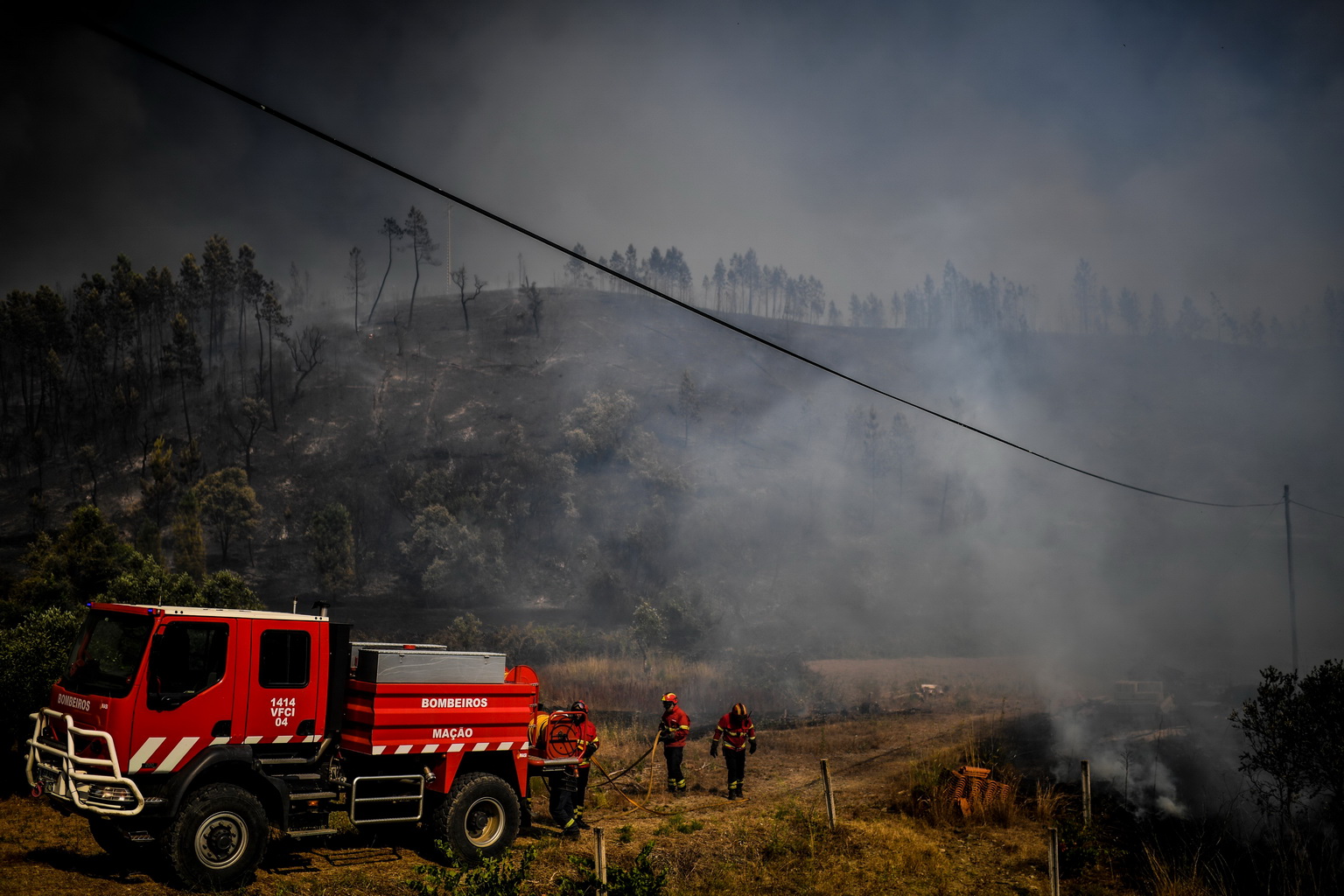7月21日，在葡萄牙中部的羅達村，消防人員在火場作業。