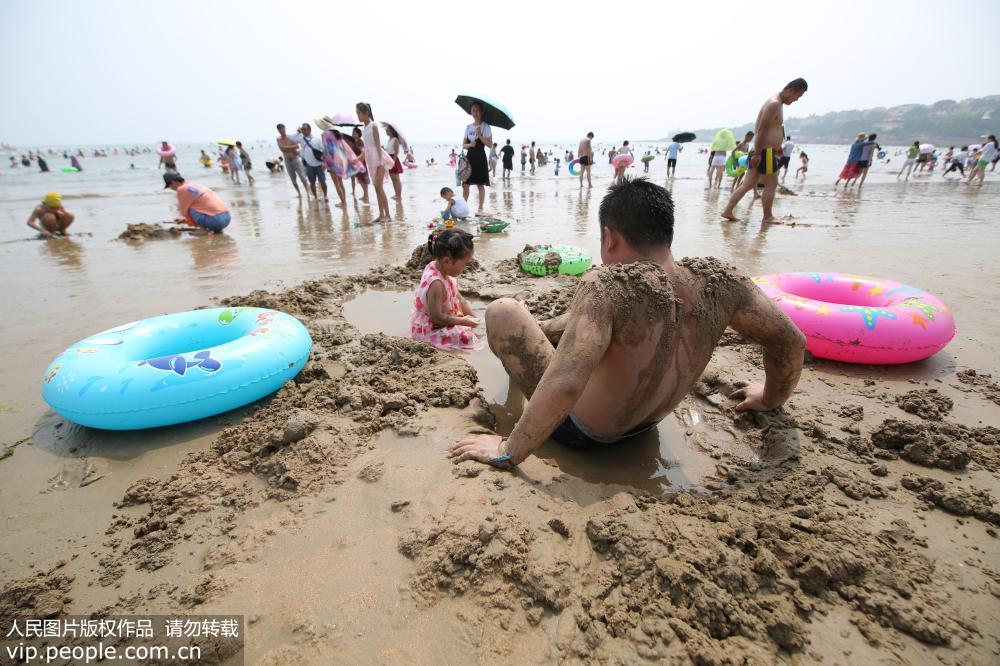 7月24日，青島海濱最高氣溫達33℃，眾多市民和游客擁到各大海水浴場洗海澡避暑。