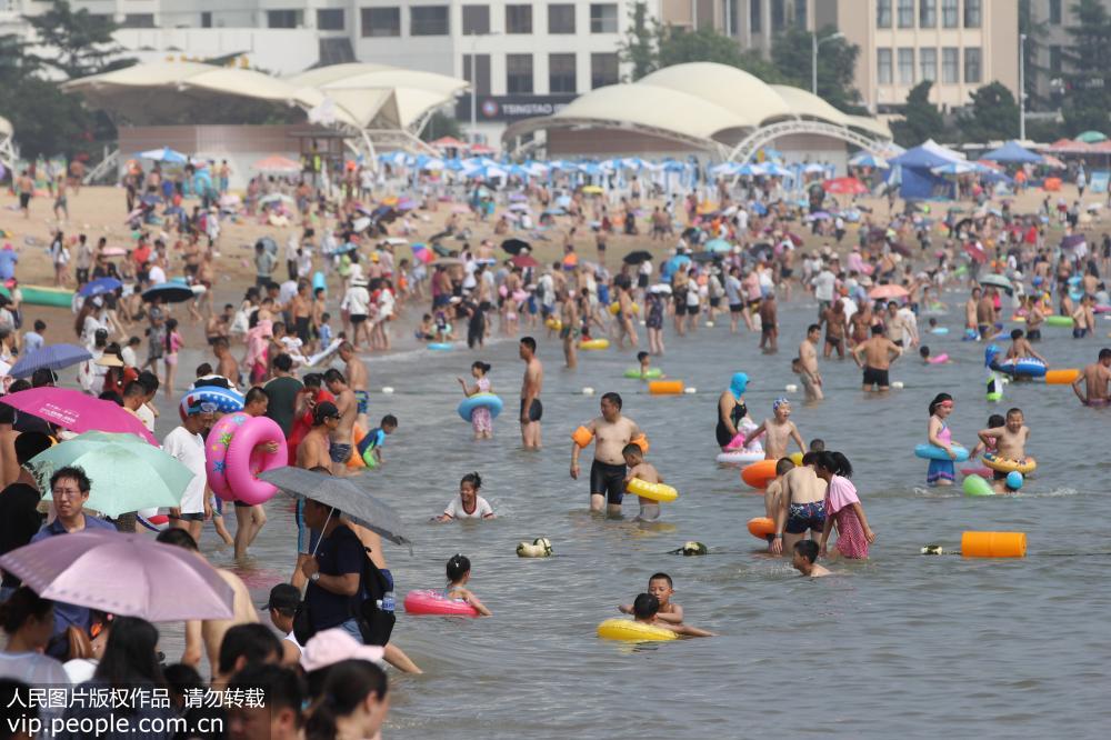 7月24日，青島海濱最高氣溫達33℃，眾多市民和游客擁到各大海水浴場洗海澡避暑。