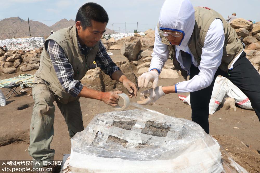 7月24日，新疆巴裡坤哈薩克自治縣海子沿鄉兩位工作人員在做聚落遺址發現的文物進行包裝保護。