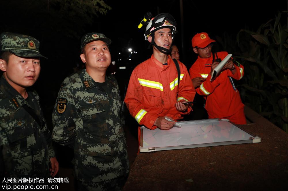 7月24日，駐地武警、消防官兵第一時間勘察山體滑坡現場。