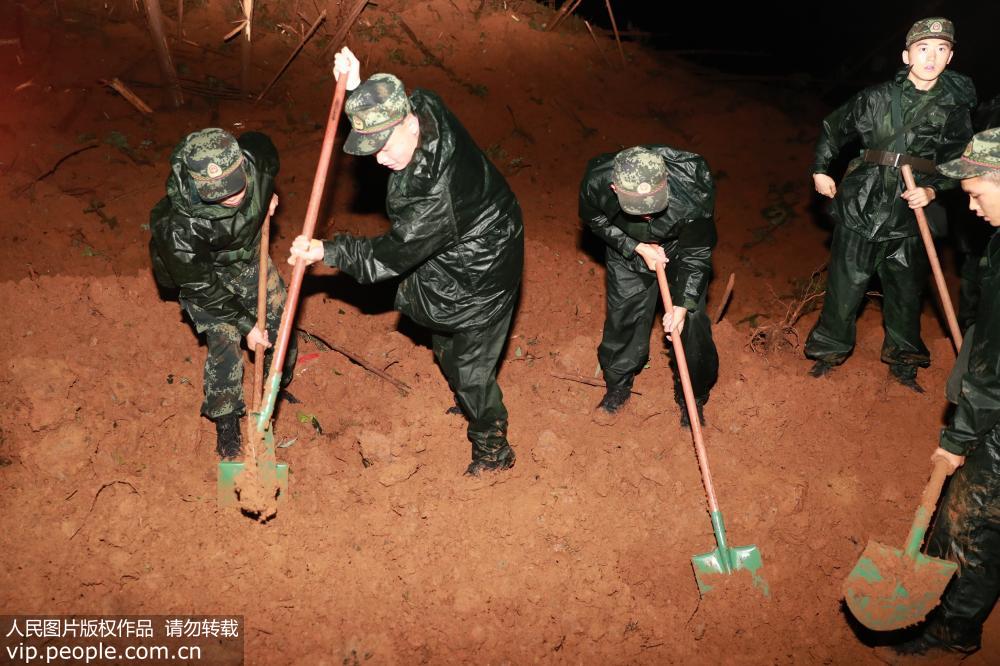 7月24日，武警官兵在山體滑坡現場緊急實施救援。