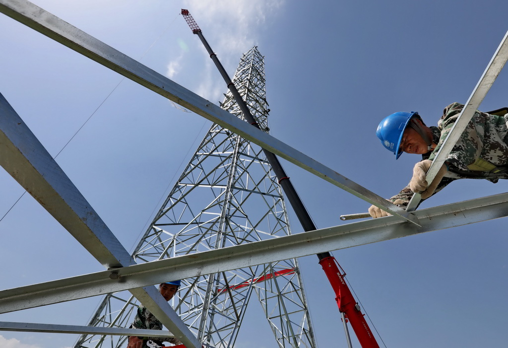 7月25日，在河北省懷安縣第六屯鄉境內，工人在張北至雄安1000千伏特高壓交流輸變電工程施工現場組立輸電線路鐵塔。