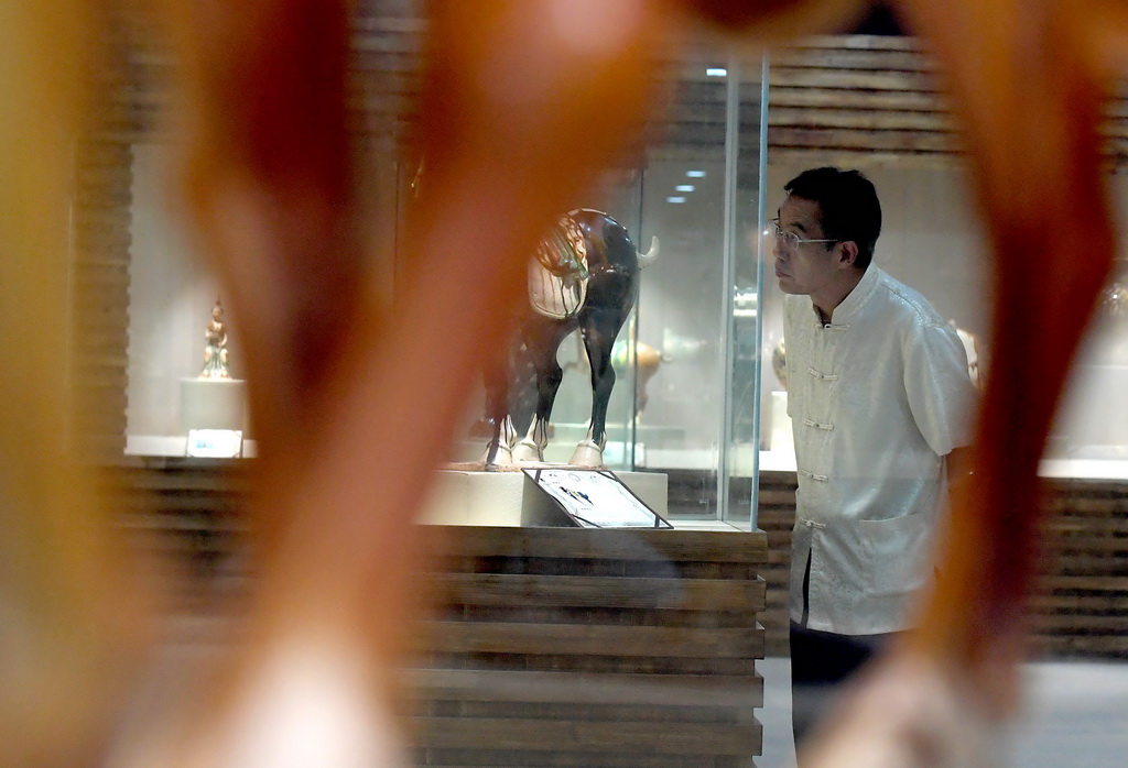 在河南省洛陽市孟津縣南石山村的作品陳列室裡，高水旺在看自己的唐三彩作品（7月23日攝）。
