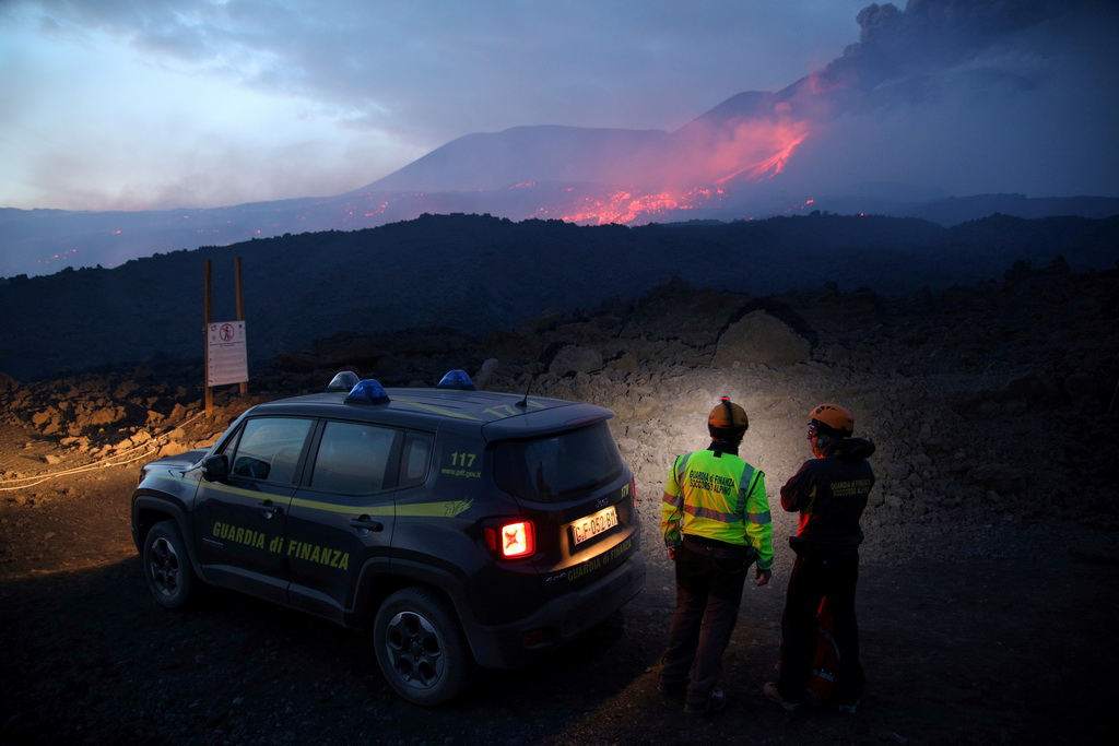 7月27日，在意大利西西里岛，救援人员眺望喷发中的埃特纳火山。