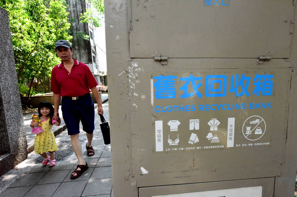 7月29日，市民從台北市一處舊衣回收箱旁經過。