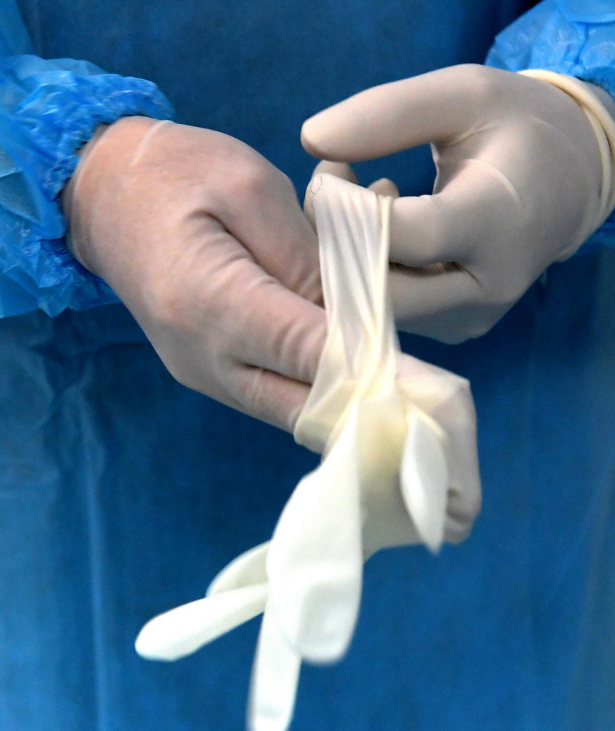 7月31日,在河南省传染病医院手术室,冯秀岭在手术前戴上第二层手套.