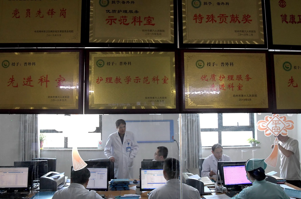 7月31日，在河南省傳染病醫院普外科醫生辦公室，馮秀嶺（左二）在和年輕醫生交流。