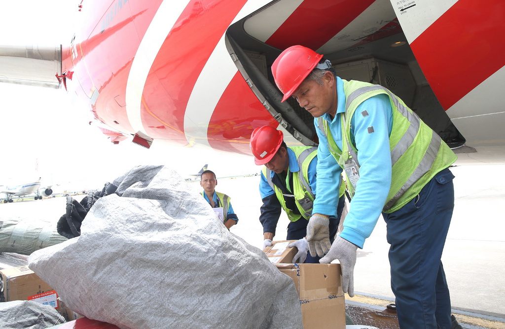 7月31日，航空行李搬運員在上海浦東國際機場卸運行李。