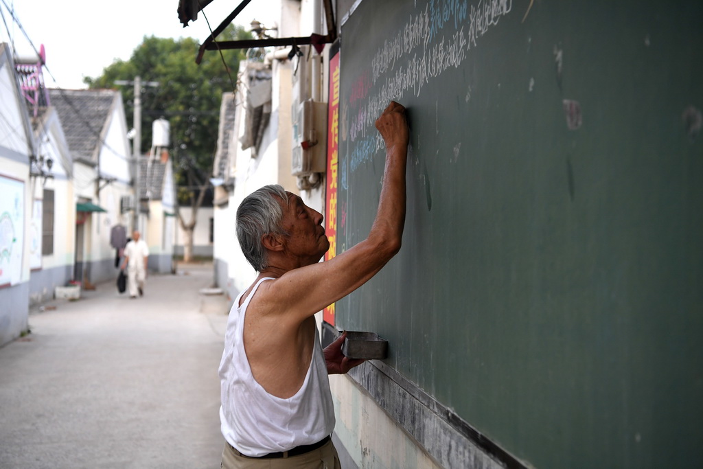 7月31日5點多，葉連平在“留守未成年人之家”教室外面的黑板上書寫新聞摘要。