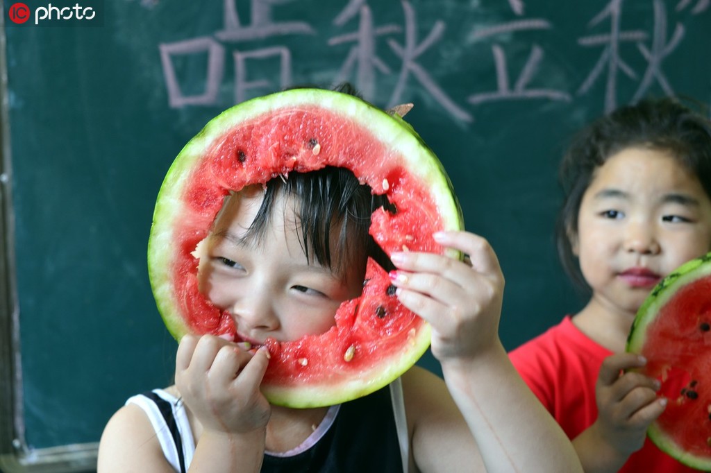 8月6日，在山东省聊城市东昌府区金领幼儿园，小朋们在吃西瓜“啃秋”。