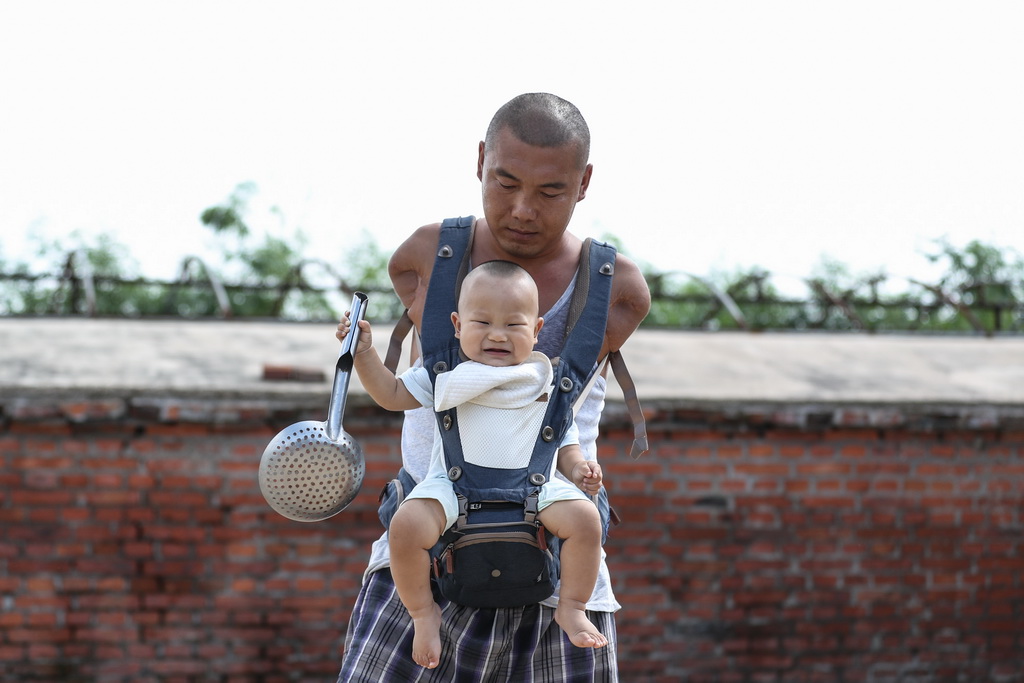 8月8日，王剛帶著兒子“肉肉”在自家院子裡玩耍。