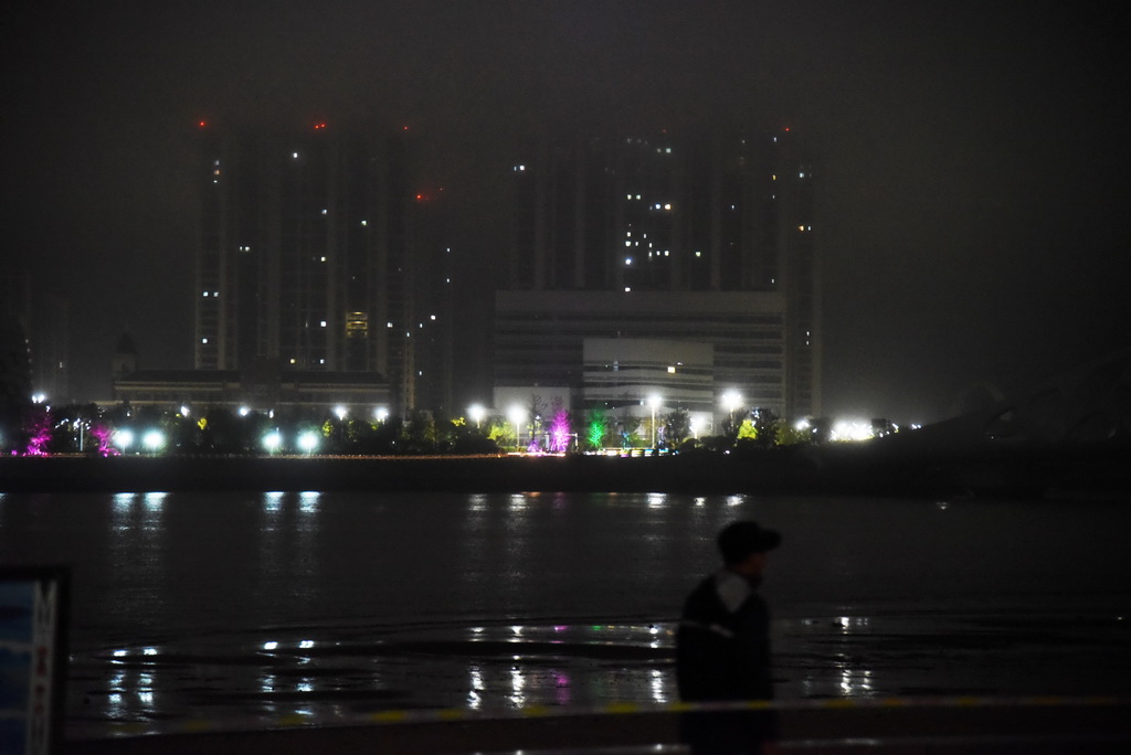 8月11日晚，一名安保人員在青島市黃島區海濱步行道執勤。新華社記者 王凱 攝