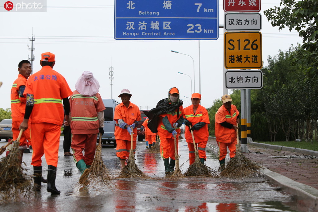 8月12日，天津市濱海新區港城大道，公路養護人員正在清理道路積水。