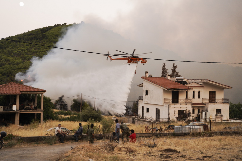 8月13日，在希腊中部埃维亚岛的马克里马利村，直升机在空中支援灭火。