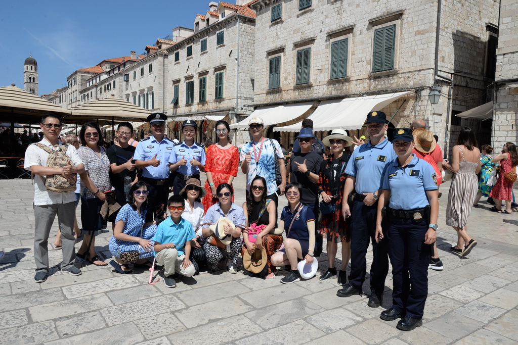 這是8月9日，參加中國與克羅地亞第二次旅游季警務聯合巡邏的警官在克羅地亞南部城市杜布羅夫尼克與游客合影。