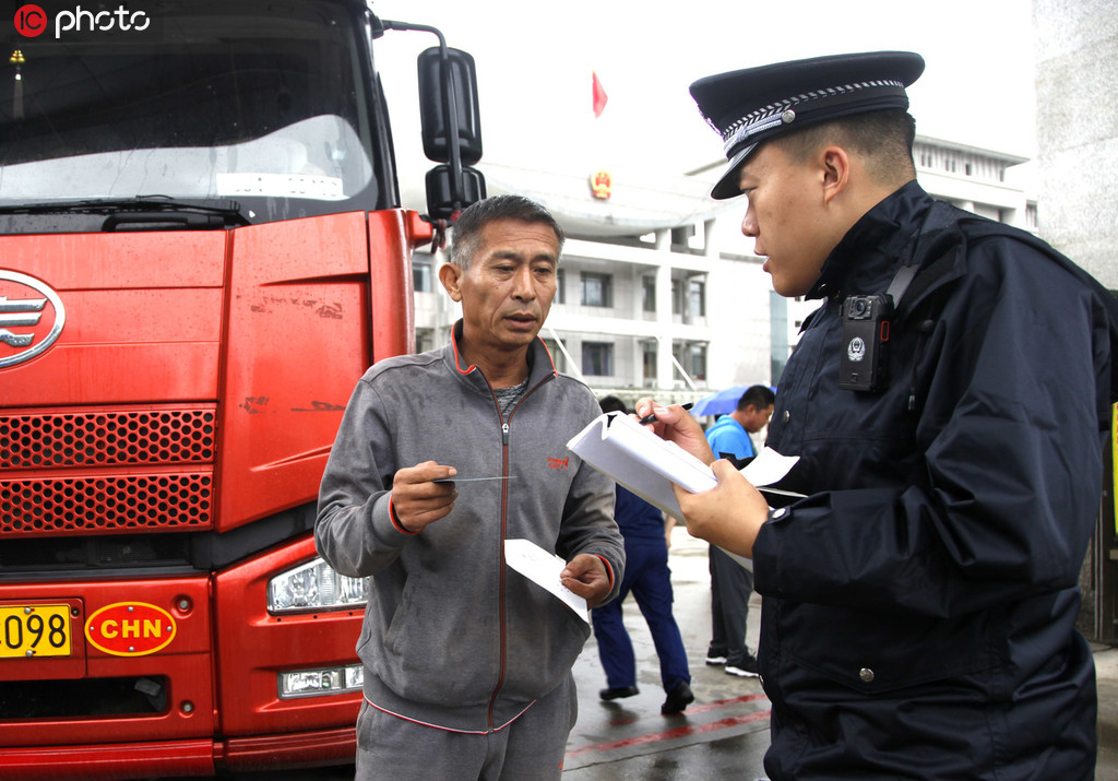 8月16日，吉林圖們口岸，一名邊檢民警為出境貨車司機辦理通關手續。