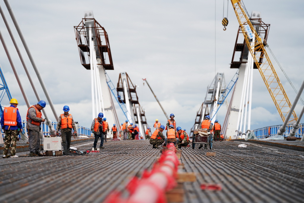 工人在大橋上進行橋面鋪裝施工作業（8月19日攝）。
