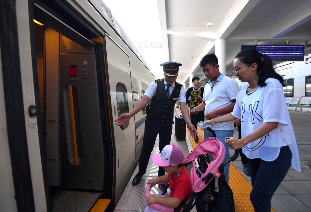 8月21日，D6622次列車乘務員在曹妃甸東站引導乘客上車。