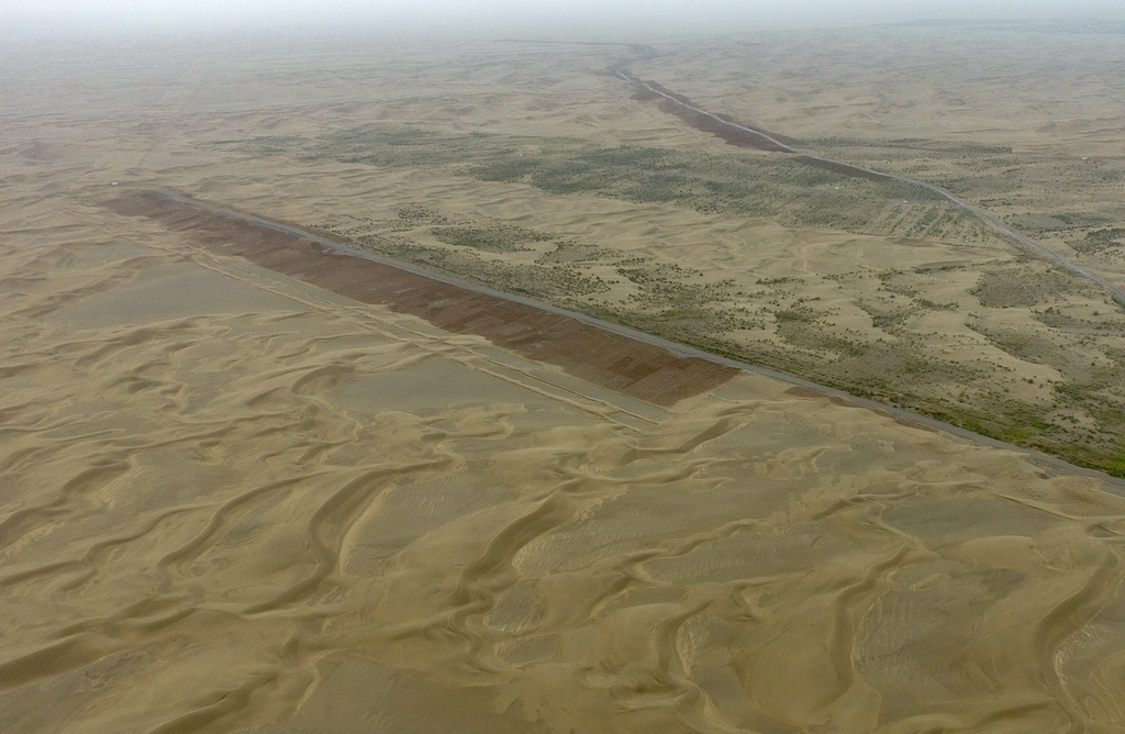 從空中俯瞰且末縣車爾臣河以東的防沙治沙綠色長廊（8月21日無人機拍攝）。新建的綠色走廊開始在沙漠裡延伸。