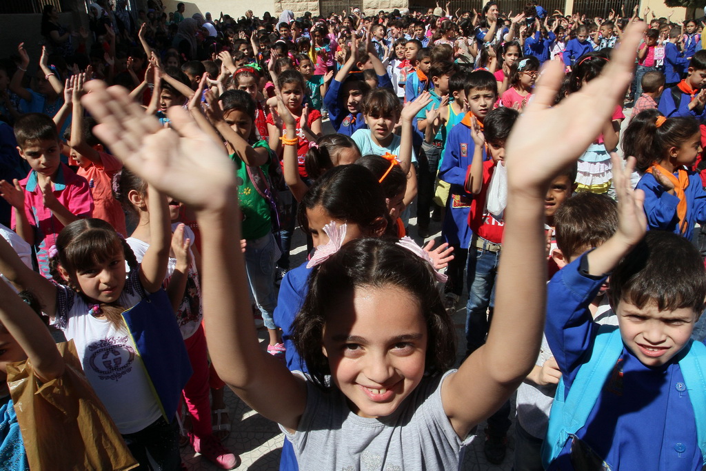 2014年9月14日，在敘利亞首都大馬士革的一所學校，第一天開學的小學生十分高興。新華社發（巴西姆·特拉維 攝）