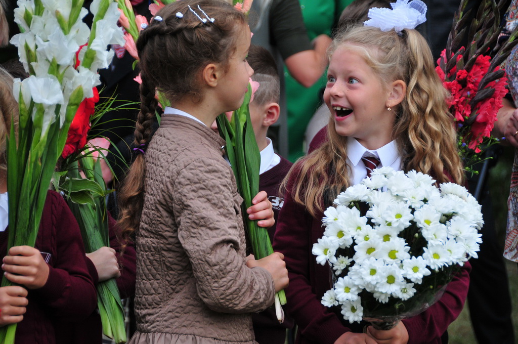 2017年9月1日，在拉脫維亞首都裡加，兩名學生手持鮮花參加開學典禮。新華社發（亞尼斯 攝）