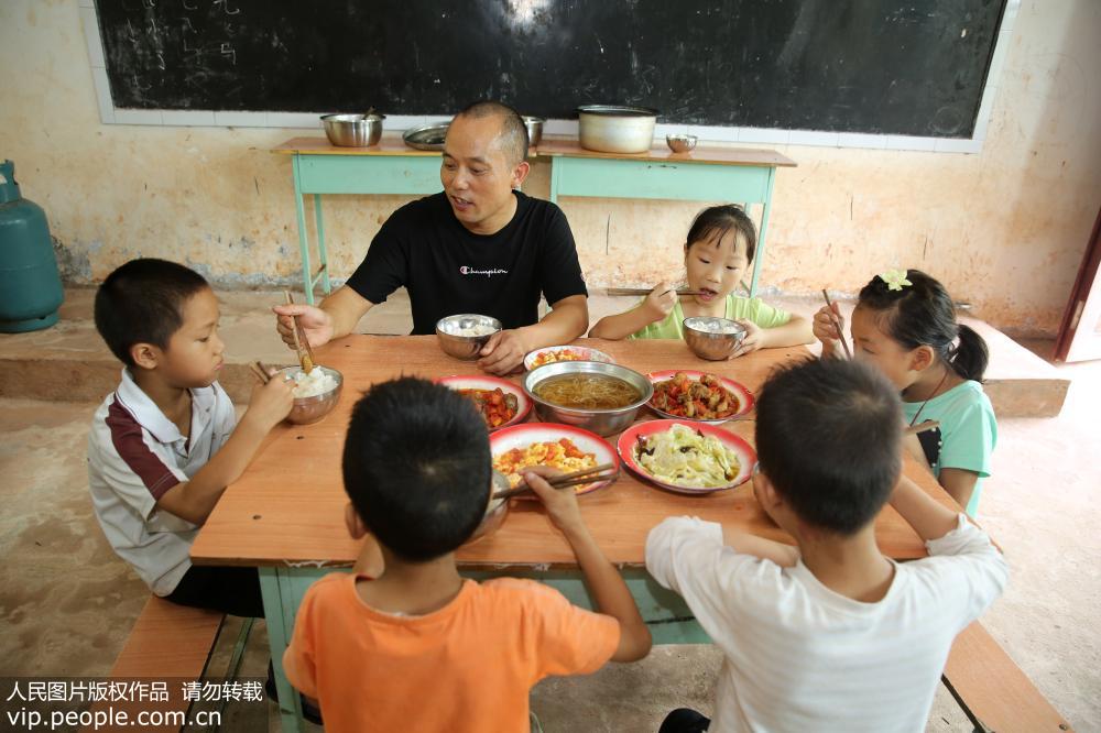 2019年9月9日，在四川省內江市東興區平坦鎮石院小學，教師張永康陪同學生吃飯。