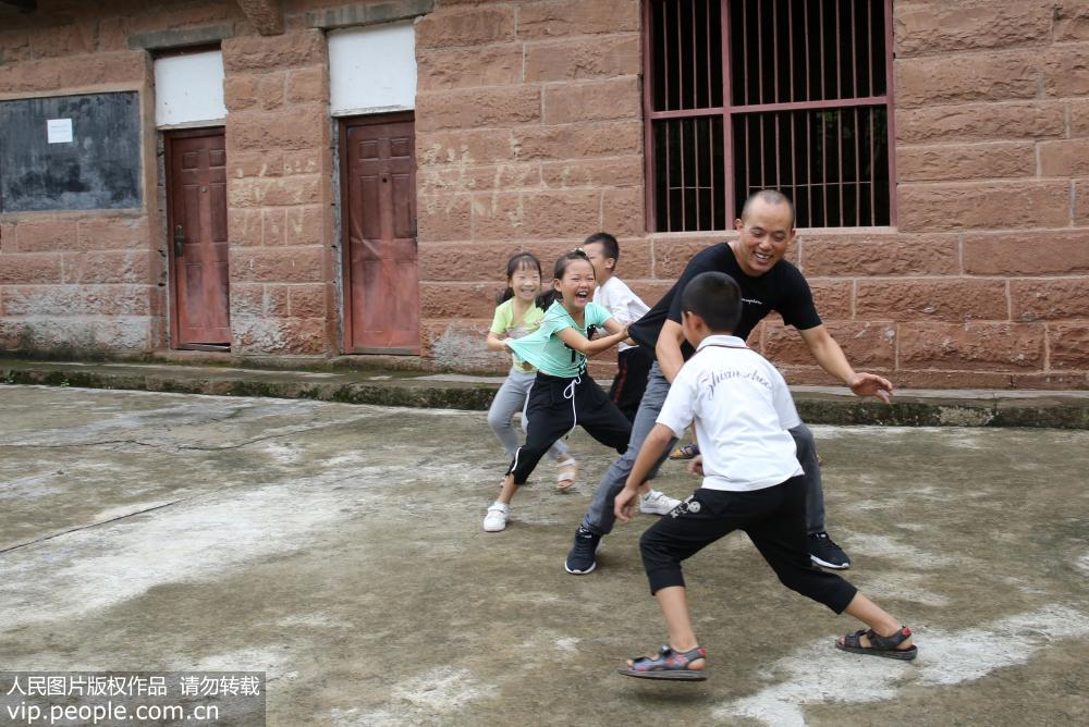 2019年9月9日，在四川省內江市東興區平坦鎮石院小學，教師張永康在課間與學生做游戲。 