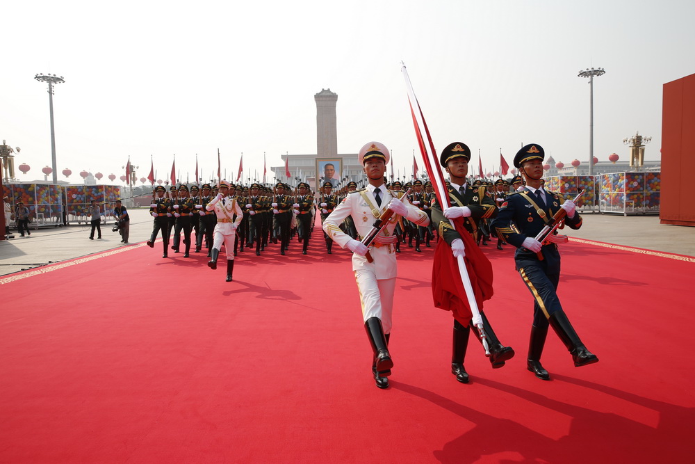 国旗护卫队从人民英雄纪念碑基座出发，走向旗杆基座。新华社记者 费茂华 摄