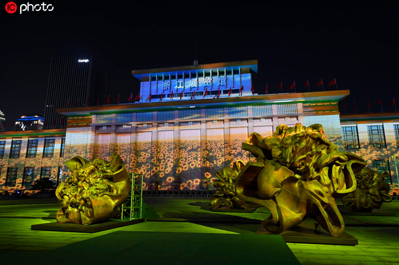 浙江展覽館建筑立面上投影的3D葵園影像與廣場上的葵園雕塑群相呼應。
