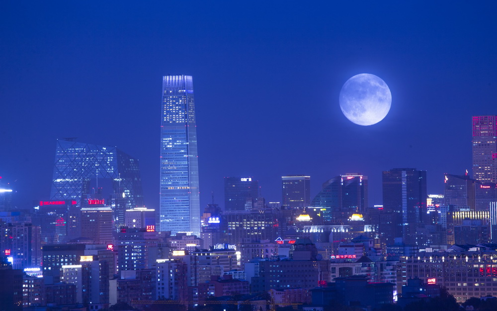 2014年9月8日中秋節，國貿中心、中央電視台、銀泰中心等北京CBD的樓群與月亮（兩次曝光）。截至2014年，北京CBD入駐企業達19000家，年均增長27%，注冊資本過億元企業184家，目前已形成以國際金融為龍頭、高端商務為主導、國際傳媒聚集發展的產業格局。  宋明昌 攝